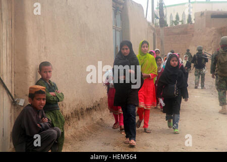 Bambini afgani guarda come esercito nazionale afghano soldati dal 5° Commando Kandak condurre una pattuglia di sicurezza durante una operazione di compensazione in Boz Qandahari, Kunduz distretto, provincia di Konduz, Afghanistan, 28 aprile. Il commando, assistito dalla coalizione di forze per le operazioni speciali, ha aiutato a stabilire la sicurezza e interrompere le attività di insorti nella regione. ANA commandos patrol Kunduz district 120429-A-BT925-001 Foto Stock