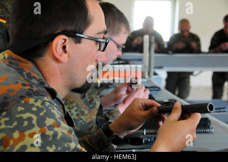 Esercito Tedesco soldati provenienti da una guida operativa Liaison Team (evitare) rimuovere il bullone dalla loro M16A2 fucili a canna rigata durante un evitare esercizio presso il Comune di multinazionale Centro Readiness (JMRC) in Hohenfels, Germania, 13 maggio 2012. Evitare XXIII e polizia guida operativa Liaison Team (POMLT) VII formazione sono progettati per preparare i team per la distribuzione in Afghanistan con la capacità di formare, consigliare e abilitare la nazionale afghano di forza di sicurezza (ANSF) in settori come quello di controinsurrezione, combattere la consulenza e la forza che consente le operazioni di supporto. (U.S. Esercito foto di Spc. Stephen Solomon/non rilasciato Foto Stock