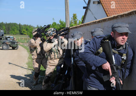 Soldati ucraini, replica uniforme afgana di polizia e soldati croati dalla Società Recon, Guardia di brigata motorizzata risma su una parete prima di ledere una casa durante una guida operativa Liaison Team (evitare) esercizio presso la multinazionale comune disponibilità centro in Hohenfels, Germania, 15 maggio 2012. Evitare XXIII e polizia guida operativa Liaison Team VII formazione sono progettati per preparare i team per la distribuzione in Afghanistan con la capacità di formare, consigliare e abilitare la nazionale afghano di forza di sicurezza in aree come di controinsurrezione, combattere advisory, forza e abilitare il supporto Foto Stock