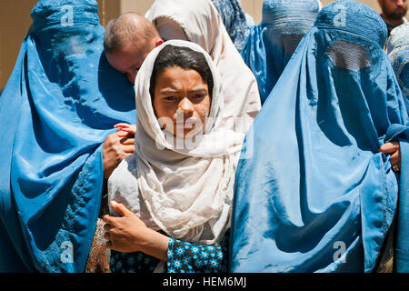 Provincia PARWAN, Afghanistan -- una giovane ragazza afgana che è appena stata trattata ad una condizione cutanea sul suo viso a egiziane di ospedale da campo attende in linea con i locali di donne e bambini per uscire Bagram Air Field. Gli afgani venuti da molto lontano per essere trattata in ospedale, il quale è gestito dall'esercito egiziano, gratuitamente. (U.S. Esercito foto di Sgt. Ken cicatrice, 7 Mobile degli affari pubblici distacco) Bagram Air Field, nativo serve con cuore grande, aiuta i bambini afghani 120603-A-ZU930-005 Foto Stock