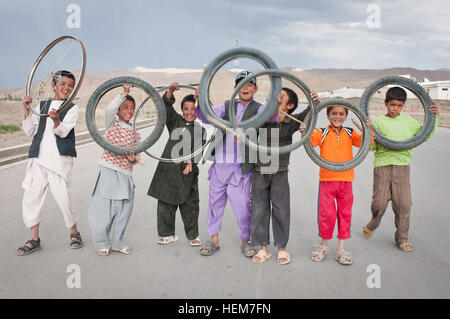 Nella provincia di Mazar-i-Sharif, Afghanistan - Locale ragazzi visualizzare i pneumatici di biciclette essi gara con su una strada vicino a inoltrare una base operativa Bamyan Giugno 24, 2012. (U.S. Esercito foto di Sgt. Ken cicatrice, 7 Mobile degli affari pubblici distacco) persone di Bamyan-2 Foto Stock