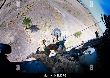 Stati Uniti Army Spc. Terry Mills, di Brandon, Miss., tira U.S. Il personale dell'esercito Sgt. Ryan Stumpff, Fort Bragg, N.C., in un Black Hawk medevac elicottero 4 Luglio in provincia Khowst, Afghanistan. Il Valkyrie medevac equipaggio stava praticando il paranco tecniche di estrazione in avanti su una base operativa di Salerno. La loro formazione è stata chiamata ad azione più tardi quello stesso giorno durante un urgente medevac chiamata che ha richiesto un totale di cinque montacarichi nella struttura ad albero-e-boulder disseminato il terreno, rendendo il funzionamento sia difficile e pericoloso. Il motivo per cui serviamo, US Army National Guard Spc. Terry Mills 647566 Foto Stock