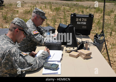 Stati Uniti Il personale dell'esercito Sgt. Jeremy Phetteplace di Manhattan, Kan., a sinistra, i record del registro di volo di un corvo il volo di prova mentre Sgt. Brian Randolph di Wichita, Kan., tenute dei punti della griglia su un laptop Toughbox per la Raven B piccolo drone a Fort Chaffee, arca. Luglio 25, 2012. Entrambi sono con l'esercito della riserva 346 Polizia Militare azienda da Fort Riley, Kan. (U.S. Esercito foto di Sgt. 1. Classe Clinton legno/RILASCIATO) Raven missione 120725-A-HX393-870 Foto Stock