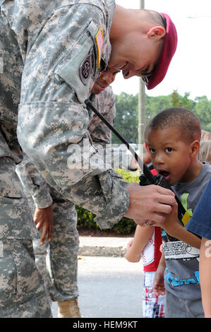 Sgt. Renald Thompson mantiene una tenuta in mano la radio per consentire ai bambini di parlare tra di loro durante un relazioni comunitarie evento a KinderCare centro diurno di Fayetteville, N.C., Sett. 5. Thompson è un segnale di avanzamento supporto sottufficiale, assegnato alla società di sede, 2° Brigata Team di combattimento, ottantaduesima Airborne Division. Egli faceva parte del gruppo dei paracadutisti dalla brigata che ha visitato KinderCare come parte di una comunità i rapporti evento per mostrare i bambini e il personale alcune delle attrezzature militari la brigata ha come un asset. Il 2BCT è in grado di distribuire ovunque nel mondo in breve tim Foto Stock