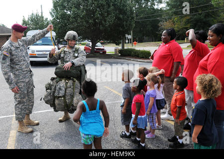 Sgt. Renald Thompson mantiene la linea statica per Spc. Adam Hesley che indossa ingranaggio necessaria per eseguire un salto da un high performance aeromobile in parte anteriore del personale e i bambini del giorno KinderCare center, durante una relazioni comunitarie caso Fayetteville, N.C., Sett. 5. Hesley è un designer grafico assegnato alla società di sede, 2° Brigata Team di combattimento, ottantaduesima Airborne Division. Thompson è un segnale di avanzamento supporto sottufficiale assegnato a HHC, 2TDB. Facevano parte del gruppo di paracadutisti da 2BCT che ha visitato KinderCare di relazioni comunitarie evento per mostrare i bambini e st Foto Stock