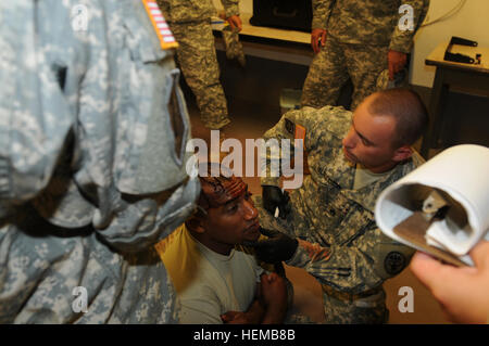 Il sergente di stato maggiore gli ottici e i valutatori del Tripler Army Medical Center hanno assistito un soldato ferito in una finta corsia di combattimento tattico durante la convalida della corsia Expert Field Medical Badge il 22 ottobre. Un gruppo di valutatori ha esaminato le prestazioni per garantire la disponibilità e la conformità agli standard per i prossimi test. Foto Stock