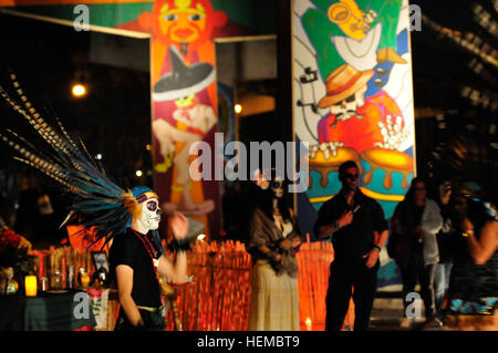 Un ballerino vestito nel tradizionale abito azteca si prende una pausa dopo aver eseguito una danza Azteca, una tradizionale danza azteca visualizzare tenutasi durante la Dia de los Muertos celebrazione presso il Lincoln Park a El Paso, nov. 4, 2012. Il concerto è stato il culmine di eventi durante il quale la presentazione di un nuovo murale di artista Gabriel S. Gaytan è stata svelata. L'evento esterno incluso artista cabine ed altari decorato con candele, offerte di cibo e fotografie incorniciate in ricordo del passato cari. (U.S. Esercito foto di Sgt. Richard Andrade xvi Mobile degli affari pubblici distacco) Dia de los Muertos Foto Stock