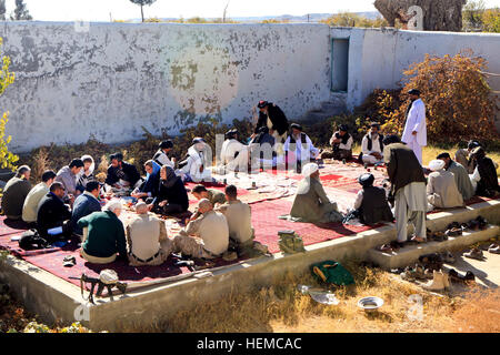 Gli anziani del villaggio, marines e il governo locale della Repubblica islamica dell'Afghanistan funzionari di godervi un tradizionale pasto afghano dopo aver discusso la governance, la sicurezza e la stabilità nella regione, nov. 29. Durante questi ultimi anni, Musa Qal'Äôah ha subito drastici cambiamenti nel tentativo di migliorare la vita del popolo afghano che vivono qui. La riunione è stata progettata per continuare i miglioramenti nella zona e per aiutare a costruire su di loro come le forze di coalizione di ritirare e autorità e responsabilità shift per il governo afgano. Repast afgano Foto Stock