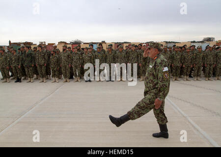 Esercito Nazionale Afghano Lt. Col. Shah Wali Zazai, comandante regionale di formazione militare Center-Southwest, truppe la linea di una formazione di ANA dai soldati durante una cerimonia di transizione a RMTC-SW nella provincia di Helmand, Afghanistan, Dic 26, 2012. La ANA ha assunto il controllo completo del RMTC-SW durante la cerimonia. La struttura è il primo RMTC in Afghanistan per tranisition ad ANA-controllo per la formazione; le operazioni e la manutenzione nel paese. È stato anche l ultimo a essere aperto nel gennaio 2010. Un team di consulenti dall'armata danese sono stati formazione e guida la ANA formatori RMTC-SW poiché Foto Stock