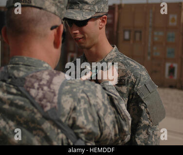 Harker Heights, Texas, nativo Col. Ricky D. Gibbs, comandante della quarta brigata di fanteria combattere la squadra, 1a divisione di fanteria, perni l esercito encomio medaglia con Valor su agente speciale Travis Guthmiller, da Jamestown, N.D., 8 giugno a inoltrare una base operativa Falcon in Rashid distretto di Baghdad. Guthmiller, che è attaccato alla 610th brigata battaglione di supporto, si è aggiudicato la medaglia per andare al di fuori della sua sfera di responsabilità per rendere aiuto medico a un soldato, salvando la sua vita. Aviatore vola al soldato Aiuto, ottiene Valor Award 49373 Foto Stock