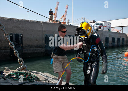 Spc. Waylon Whitley, ingegnere 74Dive distacco, distribuito dalla base comune Langley-Eustis, Virginia, tende a PFC. Brendan Milham che hanno speso più di un'ora underwater Feb. 21 in corrispondenza del punto mare di dello sbarco/imbarco, Kuwait. Ha completato la sua porzione dell'unità di saldatura subacquea esercizio mentre utilizzando una torcia raggiungendo 10.000 gradi Fahrenheit. (Foto di U.S. Army Sgt. Mica VanDyke, Terza Armata/ARCENT Affari pubblici) esercito divers splash headfirst nella formazione 130221-A-KU062-165 Foto Stock