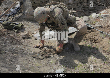 Stati Uniti Army Sgt. Isaia Myers assegnato alla bestia truppa, 1° Stormo, xxxiii reggimento di cavalleria, Task Force 3/101 scava per il sospetto di una improvvisata dispositivo esplosivo in Kote Khel village, provincia di Khost, Afghanistan, 9 marzo 2013. I soldati degli Stati Uniti ha fornito sicurezza mentre Afghan uniforme degli ufficiali di polizia cercato nelle case di persone sospettate di avere legami con i ribelli. (U.S. Esercito foto scattata da Spc. Robert Porter/RILASCIATO) 1° Stormo, xxxiii reggimento di cavalleria con AUP nella provincia di Khost 130309-A-CW939-077 Foto Stock