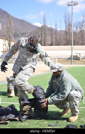 Sgt. 1. Classe Barry Miller dal Sumter, S.C., la brigata chimici, biologici, radiologici, nucleari sottufficiale in carica assegnato alla sede centrale e sede batteria, 210th incendi brigata, seconda divisione di fanteria, dà una dimostrazione della missione orientata postura di protezione cambio marcia per i medici di incendi 210th brigata con PFC. Leif Anderson da Bonita Springs, Fla., un combattimento medic assegnato alla sede centrale e sede batteria, 6° Battaglione, 37th campo reggimento di artiglieria, 210th incendi brigata, seconda divisione di fanteria, durante la formazione medica sul campo Carey su Camp Casey, Foto Stock