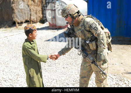 Stati Uniti Esercito Cpl. Leroy Granado, destro con la cinquantaseiesima della brigata di fanteria combattere la squadra, Texas Guardia nazionale, scuote le mani locale con un bambino afghano in corrispondenza di una stazione di polizia in Oggi Tarin Kot in provincia di Uruzgan, Afghanistan, Marzo 25, 2013. Granado è un combattimento medic per la forza di sicurezza del team di assistenza che le guide uniforme afghana i funzionari di polizia Oggi Tarin Kot. (U.S. Esercito foto di Sgt. Jessi Ann McCormick/RILASCIATO) Afghan Bomb Disposal officer di salvare vite umane in Uruzgan 130325-A-FS372-056 Foto Stock