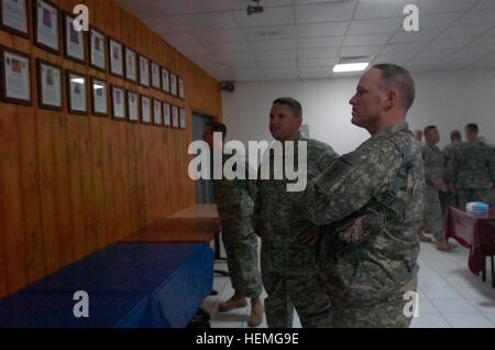 Col. Ricky Gibbs, comandante della quarta brigata di fanteria combattere la squadra, 1a divisione di fanteria da Harker Heights, Texas, guarda memorial foto di soldati che sono stati uccisi in azione sul display della marcia in avanti una base operativa Falcon Dining Facility Luglio 15. Il 'Dragon Brigata" è stato distribuito a sud di Baghdad per circa cinque mesi. Un momento per riflettere 50057 Foto Stock