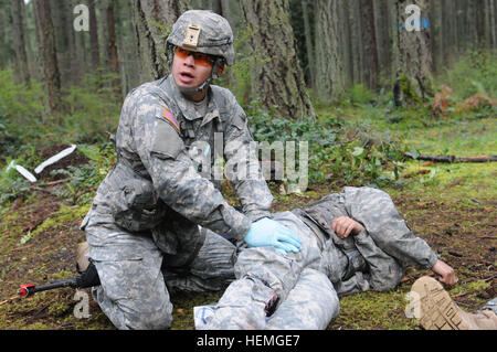 BASE COMUNE DI LEWIS MCCHORD, nello Stato di Washington - Pfc. Robert Pacheco, nativo di Amsterdam, N.Y. assegnato al decimo di combattimento ospedale di supporto, si applica pressione per la simulazione di una ferita come parte del campo di esperti medici qualifica di badge, Aprile 8. Circa 250 soldati medica da attraverso gli Stati Uniti tenta di guadagnare il campo esperto Medic Badge aprile 7-12. Di coloro che vi partecipano, una stima di 20 percento o meno beneficiare di solito alla fine.(foto da Staff Sgt. Mark Miranda, 5 Mobile degli affari pubblici distacco) Campo di esperti medici candidati Badge tentare la qualificazione 130408-A-ER359-879 Foto Stock