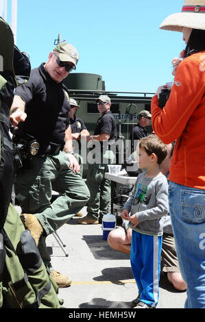 Senior Officer George Ewing con la Austin, Texas dipartimento di polizia Bomb Squad, dimostra in che modo di indossare correttamente i dispositivi di protezione ingranaggio per la Jett Berlino e la sua famiglia durante il Texas forze militari Open House presso il Camp Mabry, Texas, 20 aprile 2013. (U.S. Esercito nazionale Guard foto di Sgt. Suzanne Carter/RILASCIATO) TXMF celebra gli eroi americani 911751 Foto Stock