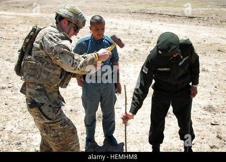 Royal Australian Army Sapper Rohan Paolo Conlon, ventesimo l'eliminazione degli ordigni esplosivi (EOD) Squadron, 1° EOD truppa e locale uniforme afghana poliziotti preparare un sito per una detonazione controllata per gli esplosivi che sono stati trovati e disarmati a Oggi Tarin Kowt nella provincia di Uruzgan, Afghanistan, Aprile 29, 2013. Forze di sicurezza nazionali afgane addestrato a fianco dei tecnici per perfezionare le loro abilità per riuscire a prendere il filo nello smaltimento delle polveri e degli esplosivi. (U.S. Esercito foto di Sgt. Jessi Ann McCormick/RILASCIATO) Texano e team australiano di avvisare la polizia Uruzgan 130429-A-FS372-711 Foto Stock