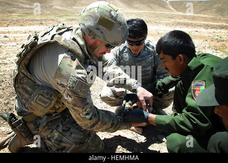 Royal Australian Navy marinaio leader Dale Johns, ventesimo l'eliminazione degli ordigni esplosivi (EOD) Squadron, 1° EOD truppa e uniforme afghana funzionario di polizia Sgt. Mohammad Dawood tape cavo di detonazione ad un blocco di esplosivi al plastico n. 4 (PE4) prima di una detonazione controllata di esplosivi trovati a Oggi Tarin Kowt nella provincia di Uruzgan, Afghanistan, Aprile 29, 2013. Forze di sicurezza nazionali afgane addestrato a fianco dei tecnici per perfezionare le loro abilità per riuscire a prendere il filo nello smaltimento delle polveri e degli esplosivi. (U.S. Esercito foto di Sgt. Jessi Ann McCormick/RILASCIATO) Texano e squadre australiane consigliare Uruzgan Polic Foto Stock