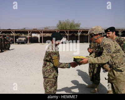 Stati Uniti Army Sgt. Tomas Martinez e l esercito nazionale afghano 1Lt. Nasir award un certificato e migliorato il kit di primo soccorso per un soldato da ANA di terza Kandak, 2° Brigata, 203rd Corps per il completamento di una lotta contro la benedizione corso in avanti una base operativa Orgun-E, Afghanistan, luglio 18, 2013. Medico afghano aumentando i fornitori di cura 130718-A-XX999-001 Foto Stock