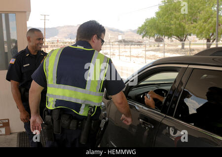 Officer Kevin Vail, centro di Fort Bliss Direzione dei Servizi di emergenza, controlli una scheda ID in corrispondenza di una voce del punto di controllo a Fort Bliss, luglio 24, mentre Lt. Hector C. Molinar, un collega des officer, guarda con un sorriso. (Foto di Staff Sgt. Jes L. Smith, XVI Mobile degli affari pubblici distacco) protezioni Gate orgogliosi di mantenere Fort Bliss sicuro e sicuro 130724-A-QY605-213 Foto Stock