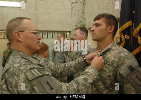 Col. Ricky Gibbs, comandante della quarta brigata di fanteria combattere la squadra, 1a divisione di fanteria da Harker Heights, Texas, perni l esercito encomio Medal on Air Force Staff Sgt. Derek Fitzhugh, un terminale comune centralina di attacco con la quarta IBCT da Port Orchard, nello Stato di Washington, nel corso di una cerimonia a inoltrare una base operativa Falcon, Sett. 15. Avieri onorato da esercito 57430 Foto Stock