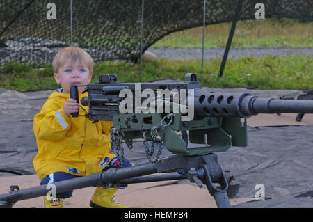 Sarà il maggiordomo, figlio di Capt. Jonathan Butler, cappellano, guarda fino dalla sua posizione di riproduzione a un M2 .calibro 50 visualizzazione statica mitragliatrice paracadutisti con il cappellano dell'unità, il 725th brigata battaglione di supporto, quarta brigata di fanteria combattere Team (airborne), XXV divisione di fanteria, uscire un Alaska National Guard C-23 Sherpa aeromobile durante il centurione battaglione del divertimento per la famiglia giorno il Agosto 28, 2013 tenutosi presso il malamute nella zona di caduta sulla giunzione base Elmendorf-Richardson, Alaska. (U.S. Foto dell'esercito da Staff Sgt. Jeffrey Smith/RILASCIATO) Centurioni famiglia invitano a Malamute Drop Zone 130828-A-ZX807-816 Foto Stock