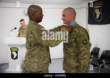 Stati Uniti Il personale dell'esercito Sgt. Joshua Cook, un cannone membro di equipaggio con una batteria, 4° Battaglione, campo 320reggimento di artiglieria, quarta brigata Team di combattimento, 101st Airborne Division (Air Assault), riceve il suo sergente Audie Murphy Club medaglione dal suo comando di battaglione sergente maggiore, il comando Sgt. Il Mag. Robert J. Johnson, durante la sua cerimonia di investitura in avanti su una base operativa fulmini, Sett. 24, 2013. (U.S. Esercito foto di Sgt. Justin A. Moeller, quarta brigata team di combattimento per Affari pubblici) Sergente Audie Murphy cerimonia di premiazione 130924-A-DQ133-104 Foto Stock