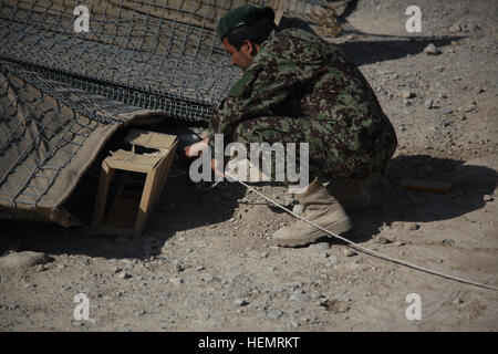 Esercito Nazionale Afghano soldato con quarta brigata di fanteria 203rd Corps ricerche di ordigni esplosivi artigianali durante un pre l'eliminazione degli ordigni esplosivi corso su Camp Maiwand, Afghanistan, Sett. 25, 2013. Questo corso di formazione aiuterà a preparare i soldati per la scuola di EOD. (U.S. Esercito foto di Spc. Ambra Stephens / rilasciato) eliminazione degli ordigni corso 130925-A-YX345-005 Foto Stock