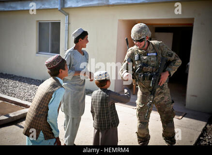 Sgt. Jeffrey Nelan, un fante con la 184forza di sicurezza del Team di Assistenza, California Guardia nazionale, gioca con bambini afgani durante un innesto di leadership presso la Afghan uniforme della sede della polizia nella provincia di Uruzgan, Afghanistan, Sett. 25, 2013. (U.S. Foto dell'esercito da Cpl. Harold Flynn l'impegno della dirigenza sicurezza 130925-A-XQ077-779 Foto Stock