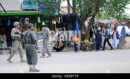 Provincia PARWAN, Afghanistan - STATI UNITI Esercito Sgt Master. Donald Demar, non commissionato ufficiale responsabile del coordinamento operativo - Centro Provinciale, tira la sicurezza accanto a una polizia nazionale afgana Officer sulla strada a Charikar fuori la levatrice academy, Aprile 10. L ANP sono state incaricate della sicurezza per un comune sforzo di protezione con l'Esercito nazionale afgano e U.S. Soldati attaccati al 1° Stormo, 172st reggimento di cavalleria, 86a brigata di fanteria combattere la squadra ad una graduazione per 29 ostetriche, Aprile 10. (Foto di U.S. Il personale dell'esercito Sgt. Whitney Hughes, Task Force Wolverine Affari pubblici) Foto Stock