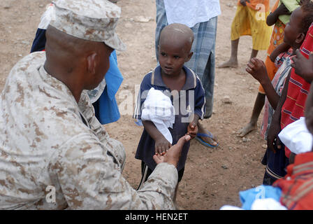 Marine Lt. Col. Aaron Potter, 3a bassa altitudine la difesa aerea comandante del battaglione, fuori di Camp Pendleton, California, scuote le mani con i figli di Nagad, Gibuti, a seguito della dedicazione di un serbatoio di acqua nel loro villaggio dic. 15. Nagad è situato nei pressi di Camp Lemonier, dove i Marines sono di stanza. 3° LAAD fornisce risorse essenziali per chiudere gli amici 69623 Foto Stock