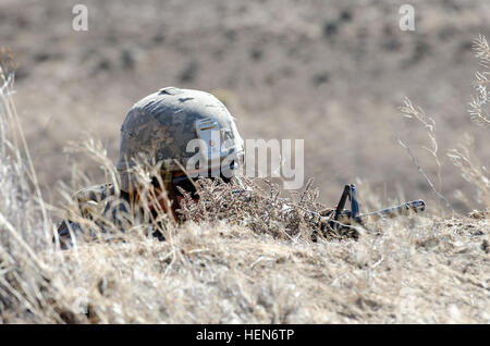 Pfc. Kainoa Mara, di Oahu, Hawaii, mantiene un belvedere dal suo combattimento difensivo posizione, istituito dal mortaio plotone, la società C, 1° Battaglione, XXIII Reggimento di Fanteria, 3-2 Stryker Brigade Combat Team, 7° Divisione di Fanteria, Base comune Lewis-Mccorda, nello Stato di Washington, durante la formazione sul campo esercizi a Yakima Training Center, 10 ottobre, 2013. Un DFP è una fossa scavata a una profondità sufficiente per stare in, con solo la testa esposta, per cui la riduzione di un soldato della sua esposizione al fuoco nemico. Essi sono spesso mimetizzata contro il rilevamento utilizzando il terreno locale per il camuffamento. (U.S. Foto dell'esercito da Staff Sgt. Chris McCullough) Tomahawks Foto Stock