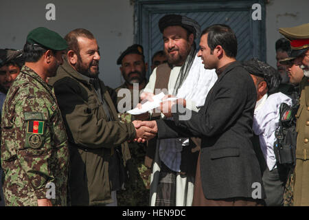 Venti quattro ex membri dei talebani reintegrata nel governo della Repubblica islamica dell'Afghanistan nel distretto di Panjwai, provincia di Kandahar, Afghanistan, Dicembre 9, 2013. Il neo reintegrato i cittadini afghani consegnato le loro armi e si sono allineati con il governo. Inoltre più di 500 libbre di gli esplosivi casalinghi e miniere raccolti negli ultimi sei mesi sono stati visualizzati per i leader afghani a vedere la produttività del Panjwai leadership. (U.S. Foto dell'esercito da Andrew PFC. Miller/ Rilasciato) Talebani reintegrata nel governo della Repubblica islamica dell'AFG Foto Stock