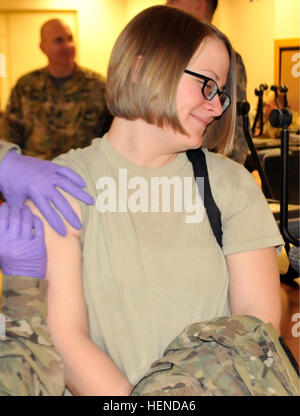 Spc. Jessica Kline, con 1° Battaglione, 52nd reggimento di aviazione, riceve il vaiolo la vaccinazione come parte del soldato pronta elaborazione al Fort Wainwright Alert Area di mantenimento a pochi minuti prima del carico su un bus che prenderà il suo e il resto del 1-52nd partito in anticipo per iniziare il loro periodo di nove mesi di deployment in Afghanistan a sostegno dell'Operazione Enduring Freedom, Marzo 20, 2014. (U.S. Foto dell'esercito da Staff Sgt. Trish McMurphy, USARAK Affari pubblici) 1-52nd Brigata Aerea distribuisce la prima ondata di Afghanistan 140320-A-RT214-585 Foto Stock