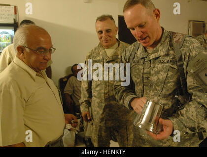 BAGHDAD - Col. Ricky Gibbs, comandante della quarta brigata di fanteria combattere la squadra, 1a divisione di fanteria e Austin in Texas, nativo, presenta un 'drago' stein di Laith Al Turk, scultore dalla regione di Doura, durante un pranzo al funzionamento in avanti Falcon di base nel sud di Baghdad, 4 aprile. È stato un incontro agrodolce per Gibbs come è stata la sua ultima riunione con Turk prima che egli redeploys entro la primavera. (U.S. Esercito foto di Spc. Nathaniel Smith, quarto BCT PAO, 1INF. Div., MND-B) (rilasciato) Stein del drago 83238 Foto Stock