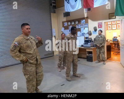 Il personale Sgt. Reinaldo Perez, mortuaria affari punto di raccolta noncommissioned officer in carica, assegnato al 111Quartermaster società fuori di Fort Lee, Va., indirizzo una squadra di soldati come PFC. Dwayne Watson viene promosso al rango di specialista al Bagram Air Field, Afghanistan. (U.S. Esercito foto di Sgt. Alfredo Hernandez) fornendo indicazioni 140627-A-AB123-001 Foto Stock