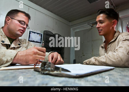 Marine Sgt. Ronald Clark, Lake Havasu City, Ariz., nativo, classe I Supervisore Cantiere assegnato a combattere il battaglione della logistica 7, sinistra, assiste il cliente nel seguire le corrette procedure per la compilazione di una richiesta di acqua forma alla classe I cantiere al Camp Leatherneck Luglio 21. Circa 90 per cento della missione è attualmente il rilascio di acqua e ghiaccio per le unità in tutta avanti base operativa. (Foto di U.S. Army Sgt. Michael K. bocchetta, decimo supporto Brigata Affari pubblici NCO)(rilasciato) Classe I servizio clienti 140721-un-CA521-048 Foto Stock