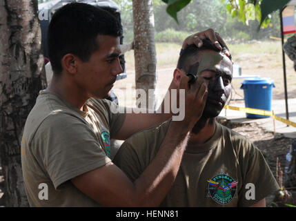 Un membro dell'Honduras per le operazioni speciali team sniper applica faccia camouflage vernice al suo partner durante il cecchino evento della levetta di comando Fuerzas 2014 a Fort Tolemaida, Colombia, luglio 26. Squadre provenienti da 17 nazioni attraverso l'Emisfero Occidentale sono in competizione da luglio 23-31, non basta per determinare un vincitore, ma anche per migliorare la loro formazione e rafforzare a livello regionale e la cooperazione multinazionale, la fiducia reciproca, la prontezza e l'interoperabilità delle forze per le operazioni speciali nella regione. Cecchini competere in distanza incognita di eventi della levetta di comando Fuerzas 2014 140726-A-AD886-611 Foto Stock