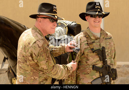 Il Mag. Gen. Michael bollette, la Combined Joint Task Force-1 comandante generale, luoghi di un abito di battaglia uniforme di prima divisione di cavalleria Patch sul manicotto di Capt. Carlos Ramirez durante la CJTF-1 patch di combattimento cerimonia presso Kandahar Airfield, 1 agosto. Il BDU patch una volta apparteneva a Ramirez del ritardo di zio, un fante che ha servito nella divisione durante l'operazione tempesta del deserto. Patch di combattimento cerimonie segnano il riconoscimento ufficiale di un soldato il diritto di indossare la loro unità patch sul loro diritto manicotto, a significare il loro servizio con una unità mentre è distribuito in una zona ostile. La prima divisione di cavalleria Headquart Foto Stock