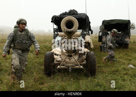 Stati Uniti I soldati della batteria alfa, 4° Battaglione, 319Airborne campo reggimento di artiglieria, 173rd Airborne Brigade controllare il perimetro del M119A2 105mm obice durante l'esercizio Saber Junction 2014 presso la multinazionale comune disponibilità centro in Hohenfels, Germania, Agosto 28, 2014. Giunzione di Saber 2014 prepara U.S., gli alleati della NATO e della sicurezza europea ai partner di condotta unificata operazioni terrestri attraverso la combinazione simultanea di offensiva e difensiva e operazioni di stabilità appropriati per la missione e l'ambiente. Ulteriori informazioni su Saber Junction 2014 possono essere trovati in http Foto Stock