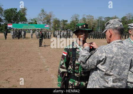 Stati Uniti Esercito Lt. Gen. Stephen Lanza, a destra il comandante generale del corpo I perni di un nastro rosso sulla spalla sinistra dell' esercito indonesiano 2 Lt. Antoni Manik, con la seconda divisione Kostrad, Tentara Nasional Indonesia segnando il ruolo dedicato della partnership le forze armate durante la cerimonia di apertura del 8° Garuda scudo 14 Esercizio a Dodiklatpur, Asem Bagus, Indonesia, Sett. 1, 2014. Garuda Shield è un regolarmente pianificate esercizio bilaterale sponsorizzato da U.S. Pacifico esercito e ospitato annualmente da Tentara Nasional Indonesia a promuovere la sicurezza regionale e la cooperazione. (U.S. Foto dell'esercito da S Foto Stock