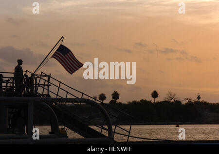 GUANTANAMO Bay a Cuba - un soldato si erge a attenzione a bordo della US Army nave Chickahominy, una grande landing craft, in attesa di abbassare la bandiera per la notte mentre è inserito in corrispondenza di U.S. Stazione navale di Guantánamo Bay, 11 maggio 2008. La nave è ancorata nella baia solo per pochi giorni prima di partire per la missione dell'antera. JTF Guantanamo conduce al sicuro e di assistenza umana e la custodia dei detenuti combattenti ostili. La JTF conduce operazioni di interrogazione per raccogliere intelligence strategica a sostegno della guerra globale al terrorismo e sostiene l'applicazione della legge e i crimini di guerra di indagini. JTF Guantanamo si è impegnata Foto Stock