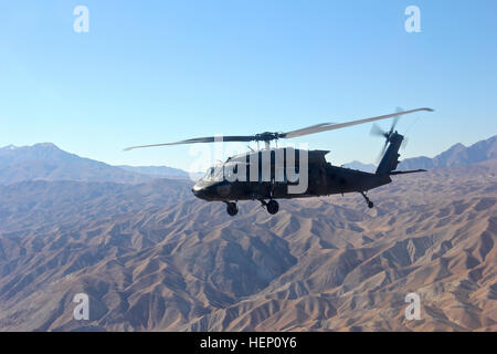 Un UH-60 Black Hawk elicottero assegnato alla Task Force Wolfpack, primo attacco battaglione di ricognizione, 82a combattere la Brigata Aerea, ottantaduesima Airborne Division vola alto oltre l'aspro paesaggio dell Afghanistan orientale su cancella il giorno 8 dicembre 2014. 1-82 ARB vola alto in oriente cieli afghano 141208-A-VO006-469 Foto Stock