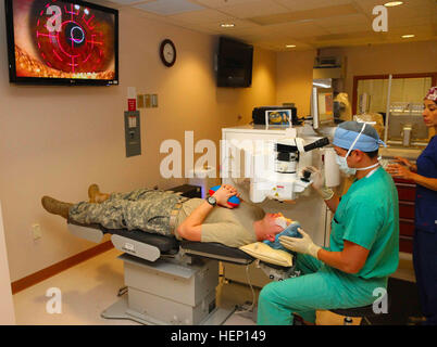 Il Mag. Dang Tam, (centro), responsabile del William Beaumont Army Medical Center" Warfighter Occhio di rifrazione Centro chirurgico, Fort Bliss, Texas, utilizza un laser ad eccimeri per eseguire la cheratectomia fotorefrattiva chirurgia su Spc. Daniel Bocanegra, (sinistra), occhio sinistro come Jessica Schnieder, (a destra), un laser refrattiva tecnico, assiste. Bocanegra, un medic assegnato alla società B, WBAMC, ha optato per la chirurgia elettiva a causa della sua scarsa capacità visiva e la sua desidera essere senza occhiali mentre esegue il suo lavoro. (U.S. Esercito Foto di Sgt. James Avery, XVI Mobile degli affari pubblici distacco) il senno di poi è 20-20, Warfig Foto Stock