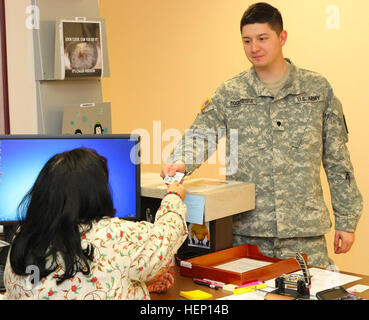 Spc. Daniel Bocanegra, (a destra), un medic assegnato alla società B, William Beaumont Army Medical Center, Fort Bliss, Texas, le mani la sua scheda di accesso comune, per scopi di identificazione, per WBAMC Warfighter rifrazione chirurgia oculare Centro tecnico di chirurgia Georgina Boisselier, (sinistra), nativo di El Paso, Texas, durante il processo di check-in prima della sua cheratectomia fotorefrattiva (PRK) procedura, che speriamo di dargli 20-20 o una migliore visione, Dic 10. Dopo la chirurgia, Bocanegra, nativo del Corpus Christi, avrà una settimana di convalescenza lasciare per il recupero e la valutazione. (U.S. Foto dell'esercito da S Foto Stock