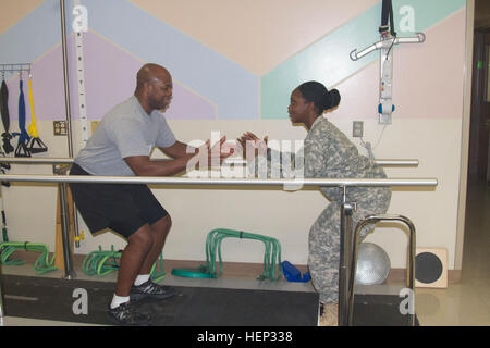 Sgt. Latonya Sharp, una terapia fisica tecnico al Madigan Army Medical Center su base comune corda Lewis-Mcmostra Master Sgt. Marvin Howard, supervisore della manutenzione meccanica, con il Guerriero Battaglione di transizione, il modo corretto per eseguire uno dei suoi molti esercizi durante la sua terapia fisica sessione, 20 gennaio, 2015. È stato tre mesi poiché Howard subì un totale la chirurgia di sostituzione del ginocchio e ha detto la Sharp ha aiutato lui mentalmente e fisicamente per arrivare a questo stadio nel suo recupero. Soldato Madigan motiva i pazienti attraverso la compassione, impegno 150120-A-RT214-002 Foto Stock