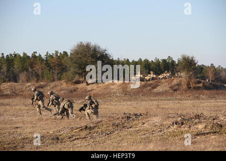 Fanti del 3° Battaglione, xv Reggimento di Fanteria, quarta brigata di fanteria combattere la squadra, terza divisione di fanteria, legato in avanti per il loro prossimo obiettivo mentre i carrelli dei soldati da armi pesanti compagnia di 3-15 Inf. Fornire fuoco di copertura durante un combinato di bracci live-fire esercitare sulla Fort Stewart, Ga., Gennaio 28, 2015. (U.S. Esercito Foto di Sgt. Joshua Laidacker, quarto IBCT, 3° ID, Affari pubblici) 3-15 fanteria, prima attraverso bracci combinata live-fire 150128-A-ZG315-486 Foto Stock