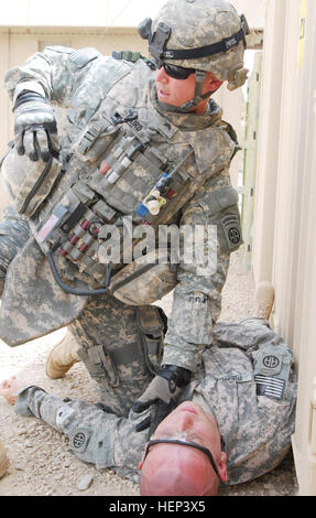 Sgt. Scott Baird di Pigeonforge, Tennessee, il medico assegnato al 2° Battaglione, 505th Parachute Reggimento di Fanteria, 3° Brigata Team di combattimento, ottantaduesima Airborne Division, Divisione multinazionale - Bagdad, raggiunge per la sua custodia medica al fine di recuperare un bendaggio per arrestare il sanguinamento eccessivo sul collo di un role-playing soldato ferito durante un trauma lane esercizio luglio 16 sul giunto di sicurezza la fedeltà della stazione si trova sulla 9 Nissan distretto orientale di Baghdad. Molti medici condotti l'esercizio al fine di mantenere le loro competenze sharp in caso di emergenza medica. I medici hone critical s Foto Stock