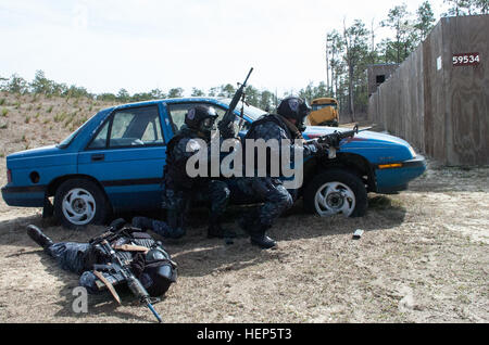 Honduregni TIGRES passare da dietro un veicolo che stavano usando come copertura come un compagno TIGRES, una simulazione di incidenti, guarda a. Il TIGRES, un contatore-traffico illecito di stupefacenti e di lotta contro la tratta di esseri umani la forza, partecipavano al culmine esercizio detenute Feb. 27 su Eglin Air Force Base di test di quasi due settimane di formazione avanzata che hanno ricevuto da berretti verdi del settimo delle forze speciali Gruppo (Airborne). Honduregni TIGRES condotta culmine esercizio ospitato da 7 forze speciali militari di gruppo 150227-A-KJ310-142 Foto Stock
